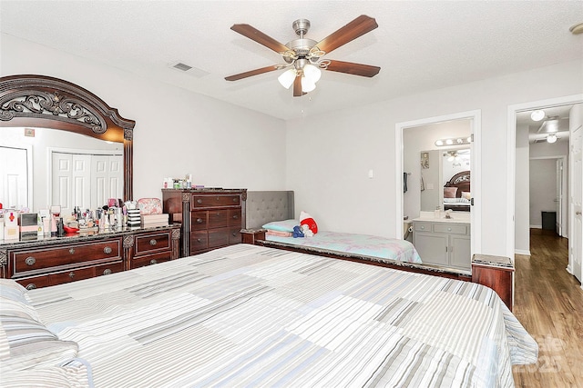bedroom featuring wood finished floors, ceiling fan, and ensuite bath