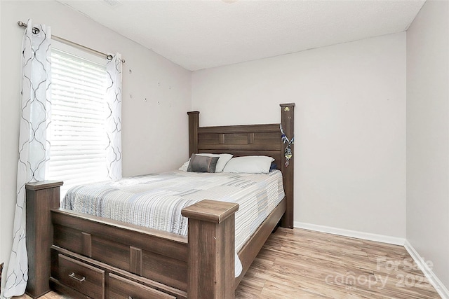 bedroom with light wood-style flooring and baseboards