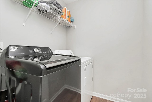 laundry room featuring separate washer and dryer, wood finished floors, and baseboards