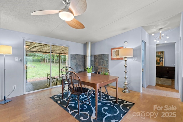 dining area featuring a ceiling fan, a textured ceiling, lofted ceiling, and wood finished floors
