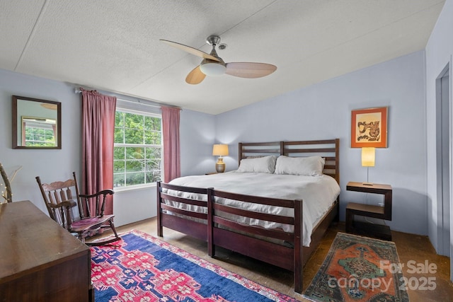 bedroom with a ceiling fan and a textured ceiling