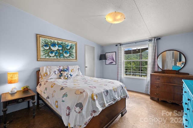 bedroom featuring lofted ceiling and a textured ceiling