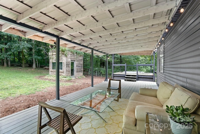 view of patio featuring a hot tub, a deck, and an outdoor structure