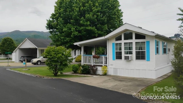 view of front facade with a porch, a carport, and a mountain view