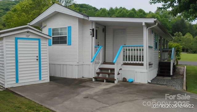 rear view of property with a shed and an outbuilding