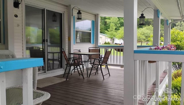 deck with a porch and outdoor dining area
