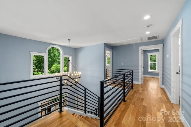 68 Bamboo Trl, Candler, NC 28715 - hallway featuring an upstairs landing, attic access, light wood-style floors, baseboards, and a chandelier