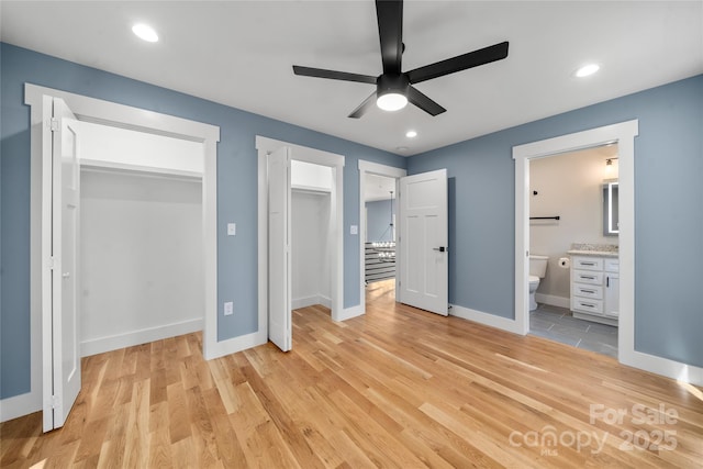 68 Bamboo Trl, Candler, NC 28715 - unfurnished bedroom with light wood-style flooring, baseboards, recessed lighting, ensuite bath, and two closets