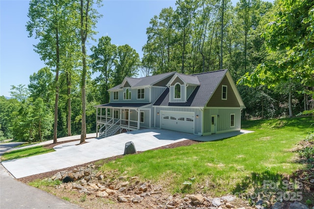68 Bamboo Trl, Candler, NC 28715 - view of front of home featuring board and batten siding, a porch, concrete driveway, a front yard, and an attached garage