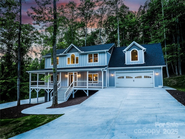 68 Bamboo Trl, Candler, NC 28715 - view of front facade with board and batten siding, a porch, driveway, and view of scattered trees