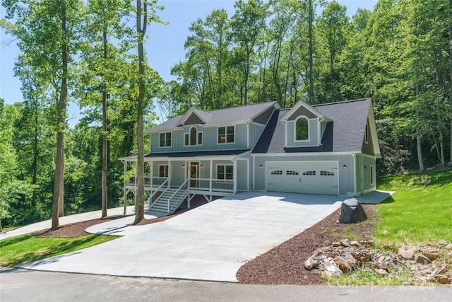 68 Bamboo Trl, Candler, NC 28715 - view of front of property with covered porch, board and batten siding, concrete driveway, a shingled roof, and a front lawn