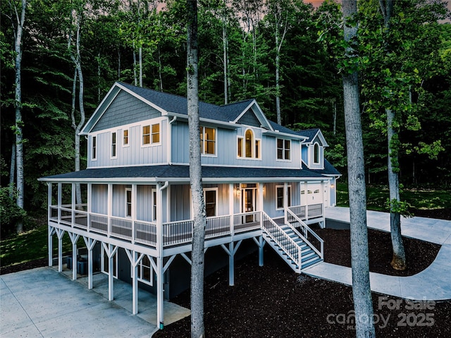 68 Bamboo Trl, Candler, NC 28715 - view of front facade with concrete driveway, a porch, board and batten siding, a garage, and roof with shingles