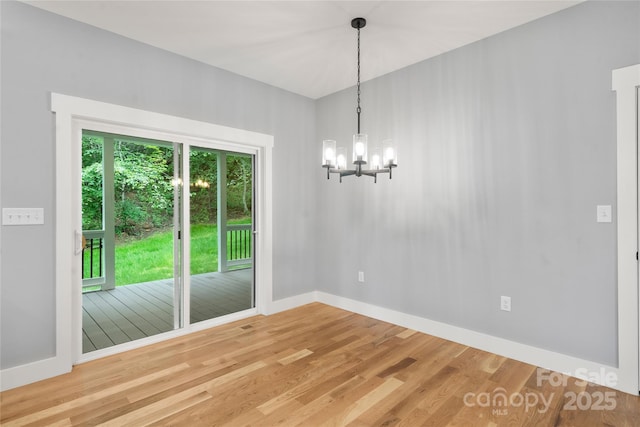 68 Bamboo Trl, Candler, NC 28715 - unfurnished dining area featuring light wood-style flooring, a chandelier, and baseboards
