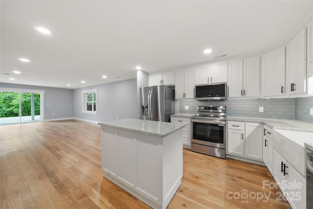 68 Bamboo Trl, Candler, NC 28715 - kitchen featuring stainless steel appliances, a kitchen island, decorative backsplash, white cabinetry, and recessed lighting