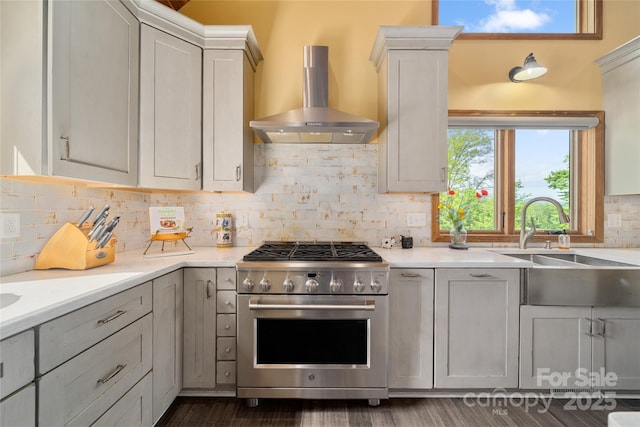 134 Olivia Trace Dr, Fletcher, NC 28732 - kitchen featuring high end stove, wall chimney range hood, tasteful backsplash, light countertops, and dark wood-style floors