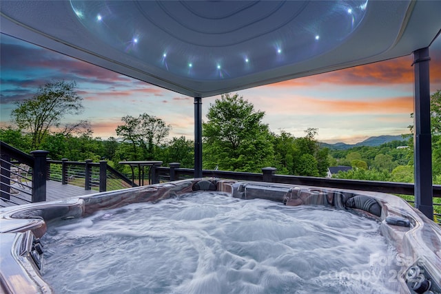 134 Olivia Trace Dr, Fletcher, NC 28732 - patio terrace at dusk with a hot tub, a wooden deck, and view of scattered trees