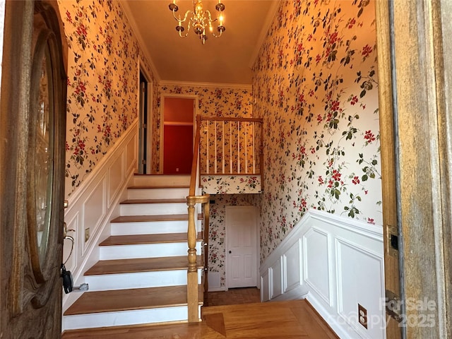 5495 Valley Run St, Hickory, NC 28601 - stairway featuring wallpapered walls, wainscoting, a decorative wall, ornamental molding, and a chandelier