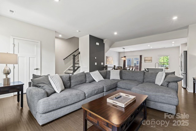 living area featuring stairway, dark wood-style flooring, and recessed lighting