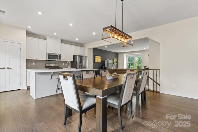 dining space with dark wood-type flooring, recessed lighting, and baseboards