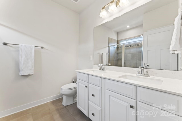 bathroom featuring baseboards, a stall shower, double vanity, toilet, and tile patterned floors