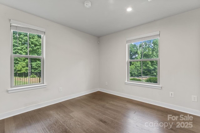 empty room with baseboards, dark wood-style floors, a smoke detector, and recessed lighting