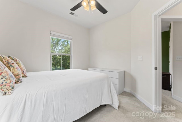 bedroom featuring light carpet, a ceiling fan, and baseboards