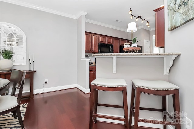 10378 Alexander Martin Ave, Charlotte, NC 28277 - kitchen featuring black microwave, a kitchen breakfast bar, dark wood-style floors, ornamental molding, and baseboards