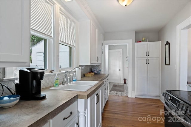 415 Norwood St SW, Lenoir, NC 28645 - kitchen featuring a sink, white cabinetry, backsplash, black electric range, and wood finished floors
