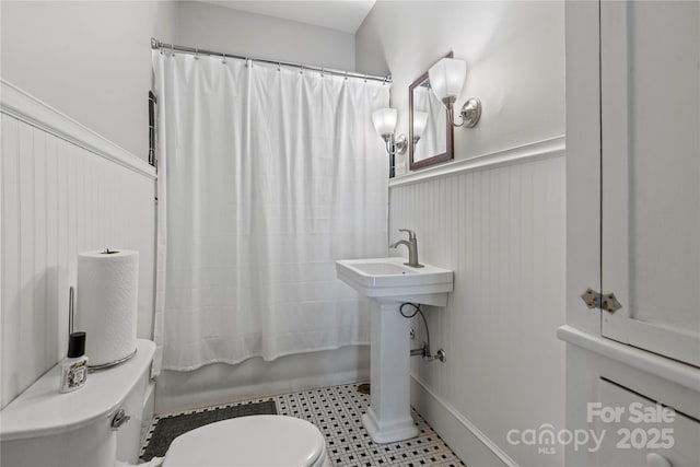 415 Norwood St SW, Lenoir, NC 28645 - full bathroom featuring toilet, wainscoting, shower / bath combo with shower curtain, and a sink