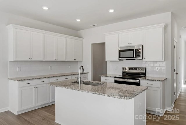 2716 Lehigh Rd, Charlotte, NC 28208 - kitchen featuring stainless steel appliances, a sink, white cabinetry, a center island with sink, and tasteful backsplash