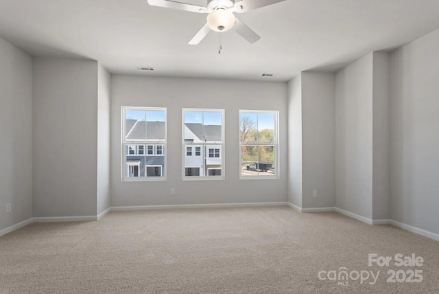 carpeted empty room with healthy amount of natural light, baseboards, and ceiling fan