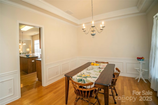 6310 Highland Commons Rd, Charlotte, NC 28269 - dining area with a chandelier, light wood-type flooring, ornamental molding, wainscoting, and a decorative wall