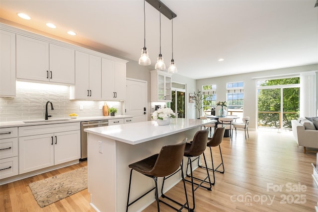 2845 Lakefront Dr, Belmont, NC 28012 - kitchen with stainless steel dishwasher, a sink, a kitchen bar, light countertops, and white cabinets