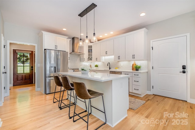 2845 Lakefront Dr, Belmont, NC 28012 - kitchen with stainless steel appliances, wall chimney range hood, a breakfast bar, white cabinetry, and a kitchen island
