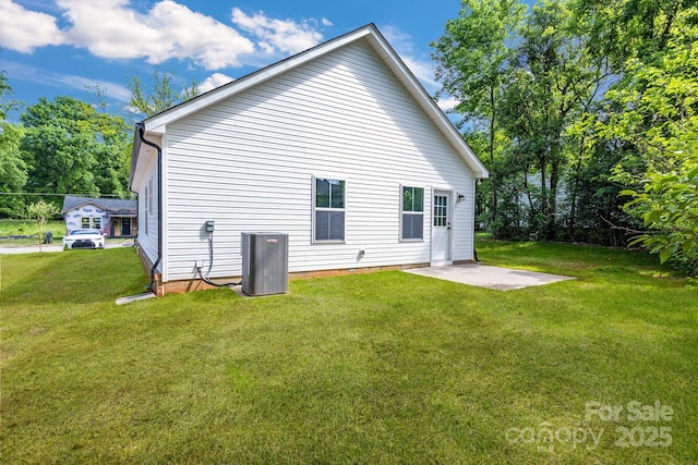 rear view of house with central AC unit, a lawn, and a patio