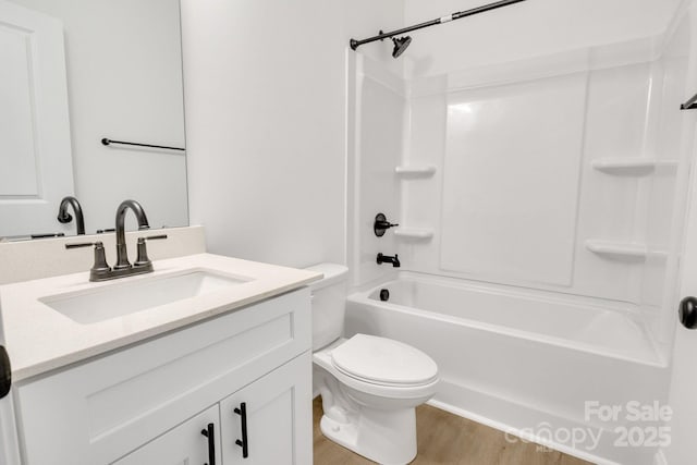 bathroom featuring wood finished floors, toilet, vanity, and bathing tub / shower combination