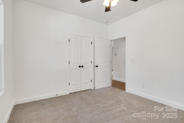 unfurnished bedroom featuring carpet, baseboards, and a ceiling fan