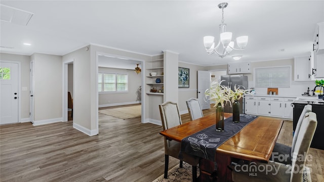 7860 Henry Harris Rd, Fort Mill, SC 29707 - dining area featuring light wood-style flooring, baseboards, a chandelier, crown molding, and ceiling fan
