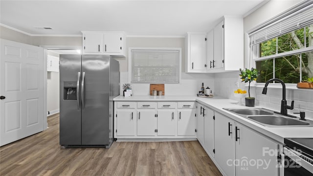 7860 Henry Harris Rd, Fort Mill, SC 29707 - kitchen with stainless steel appliances, a sink, light countertops, decorative backsplash, and ornamental molding