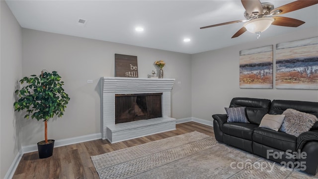 7860 Henry Harris Rd, Fort Mill, SC 29707 - living area featuring wood finished floors, baseboards, a ceiling fan, a fireplace, and recessed lighting