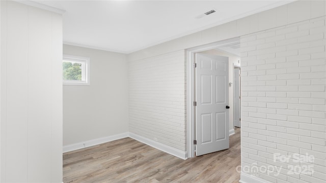7860 Henry Harris Rd, Fort Mill, SC 29707 - unfurnished room with light wood-style flooring, baseboards, brick wall, and ornamental molding
