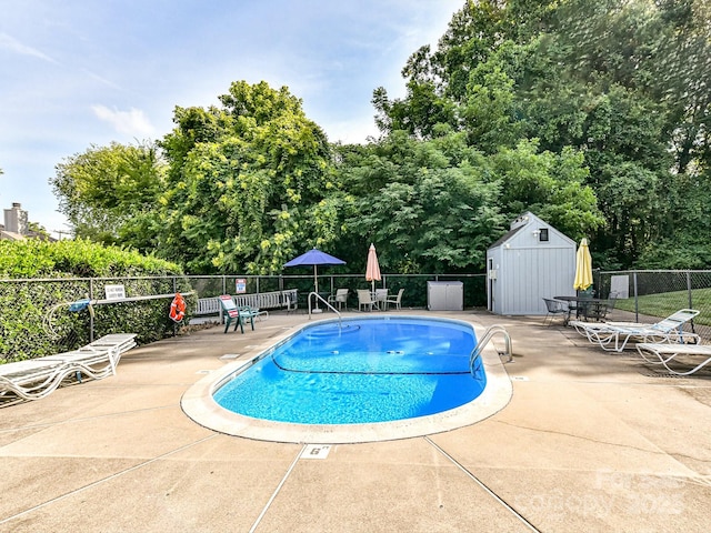 100 Willow Run Dr Unit 26, Gastonia, NC 28056 - community pool featuring fence, a patio area, a storage unit, an outbuilding, and view of scattered trees
