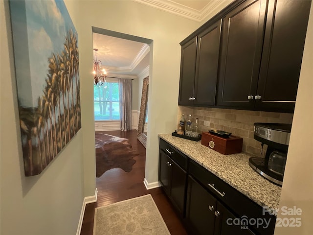 bar with ornamental molding, backsplash, dark wood-style flooring, baseboards, and a chandelier