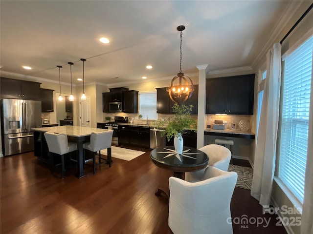 dining room featuring a chandelier, ornamental molding, dark wood-style flooring, and recessed lighting