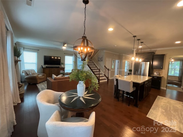 dining area featuring stairway, dark wood finished floors, a chandelier, ornamental molding, and recessed lighting
