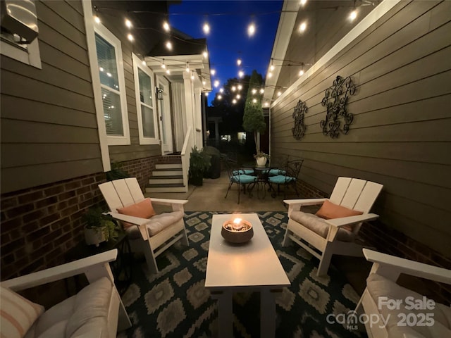 patio at night featuring a fire pit