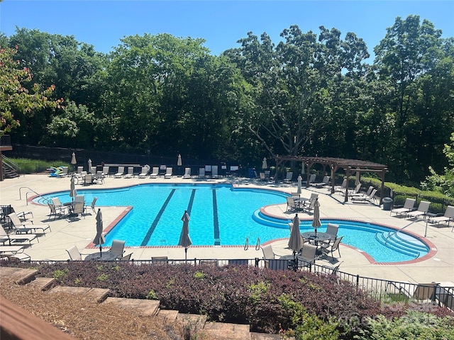 community pool featuring fence, a patio, and a pergola