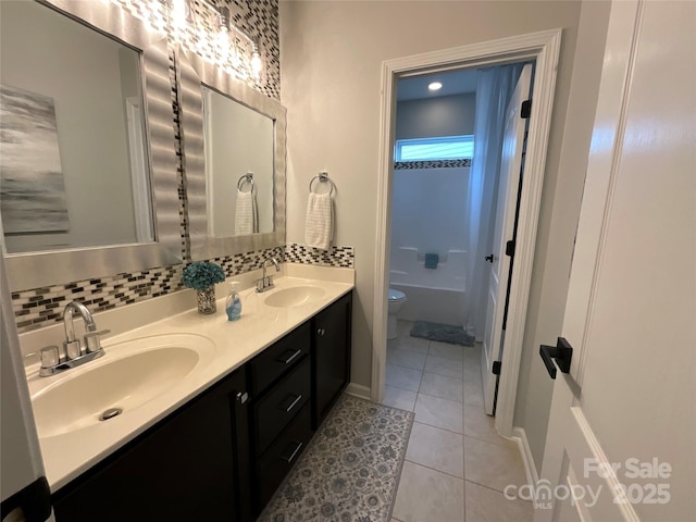 bathroom with tile patterned flooring, double vanity, toilet, a tub, and tasteful backsplash