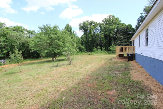 view of green lawn with a deck