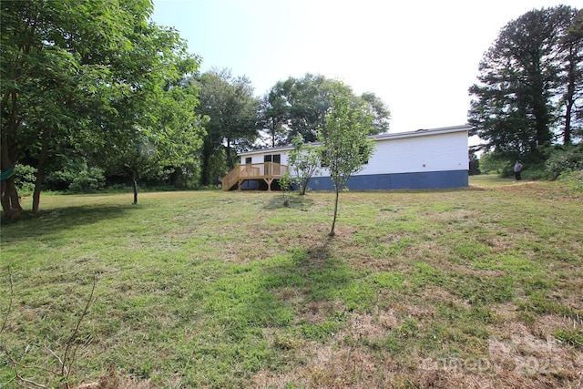 view of grassy yard featuring a wooden deck
